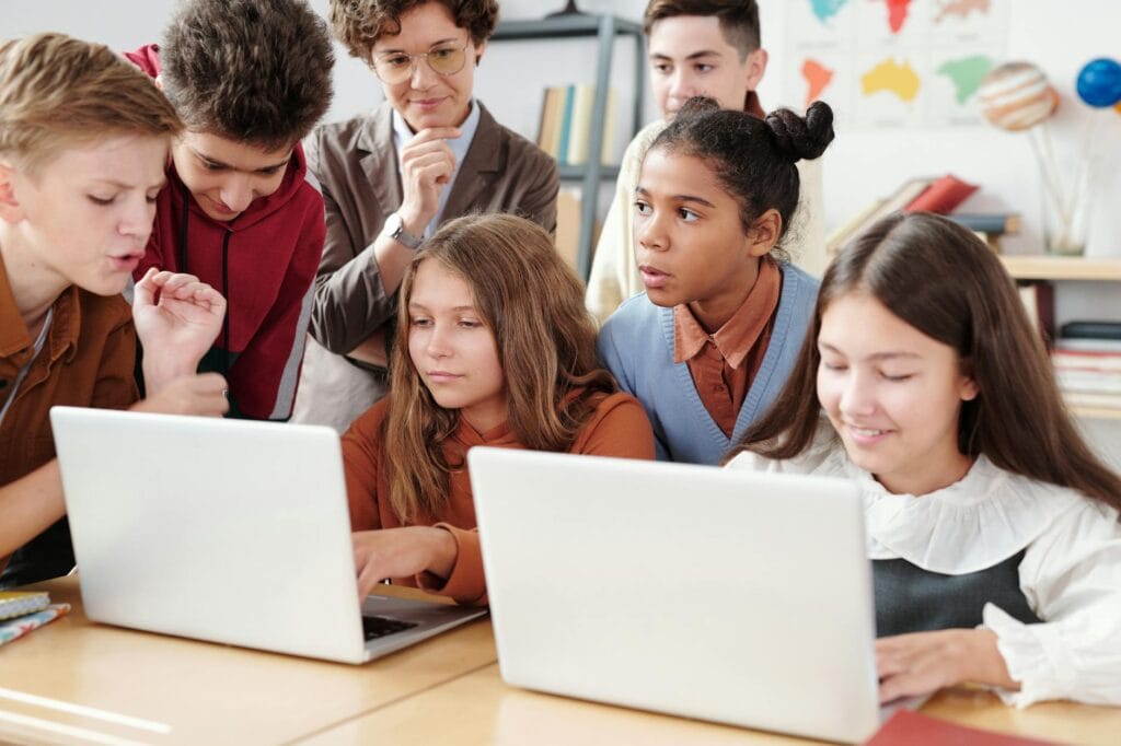 Un gruppo di studenti lavora insieme su due laptop in classe